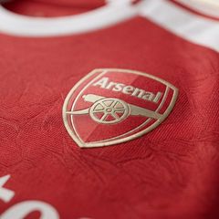 Arsenal 2025/26 home jerseys hanging in a dressing room.